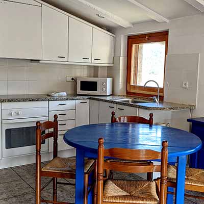 Cuina-menjador de l'apartament blau de 2 habitacions de la casa de turisme rural de Planademunt - Santa Pau - La Garrotxa
