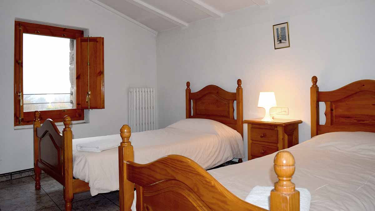 Habitació amb 2 llits individuals de l'apartament blau de 2 habitacions de la casa de turisme rural de Planademunt - Santa Pau - La Garrotxa
