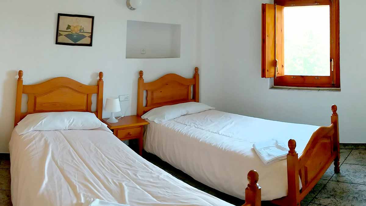 Habitació amb 2 llits individuals de l'apartament groc de 2 habitacions de la casa de turisme rural de Mas El Carrer - Santa Pau - La Garrotxa